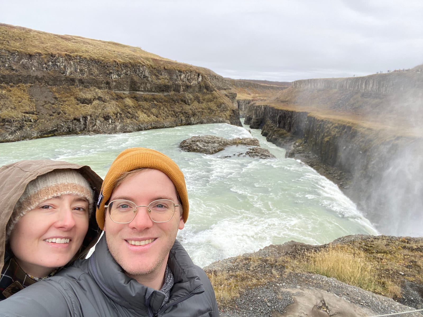 Two travelers above the Hvita river rushing toward the Gullfoss canyon