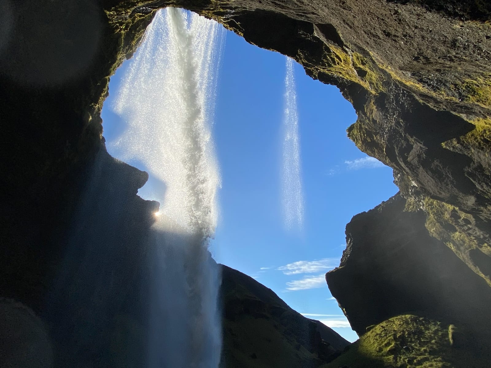 A mossy slot canyon with a waterfall at the back at Nauthusagil