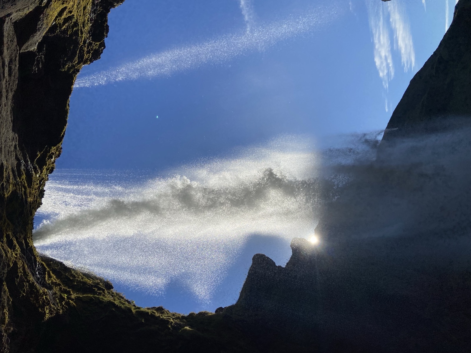 Seljalandsfoss dropping off a green cliff in low afternoon sun