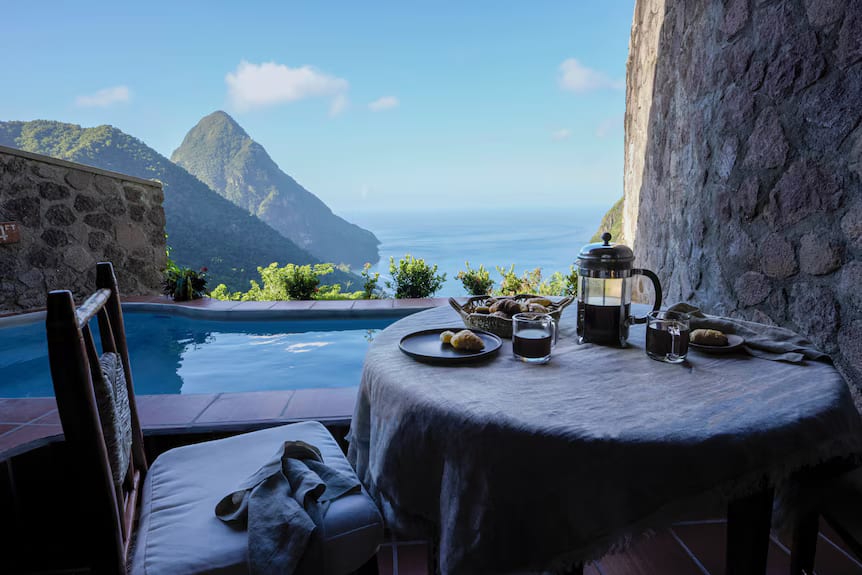 An open-wall room with a plunge pool and breakfast set out over a Piton view at Ladera