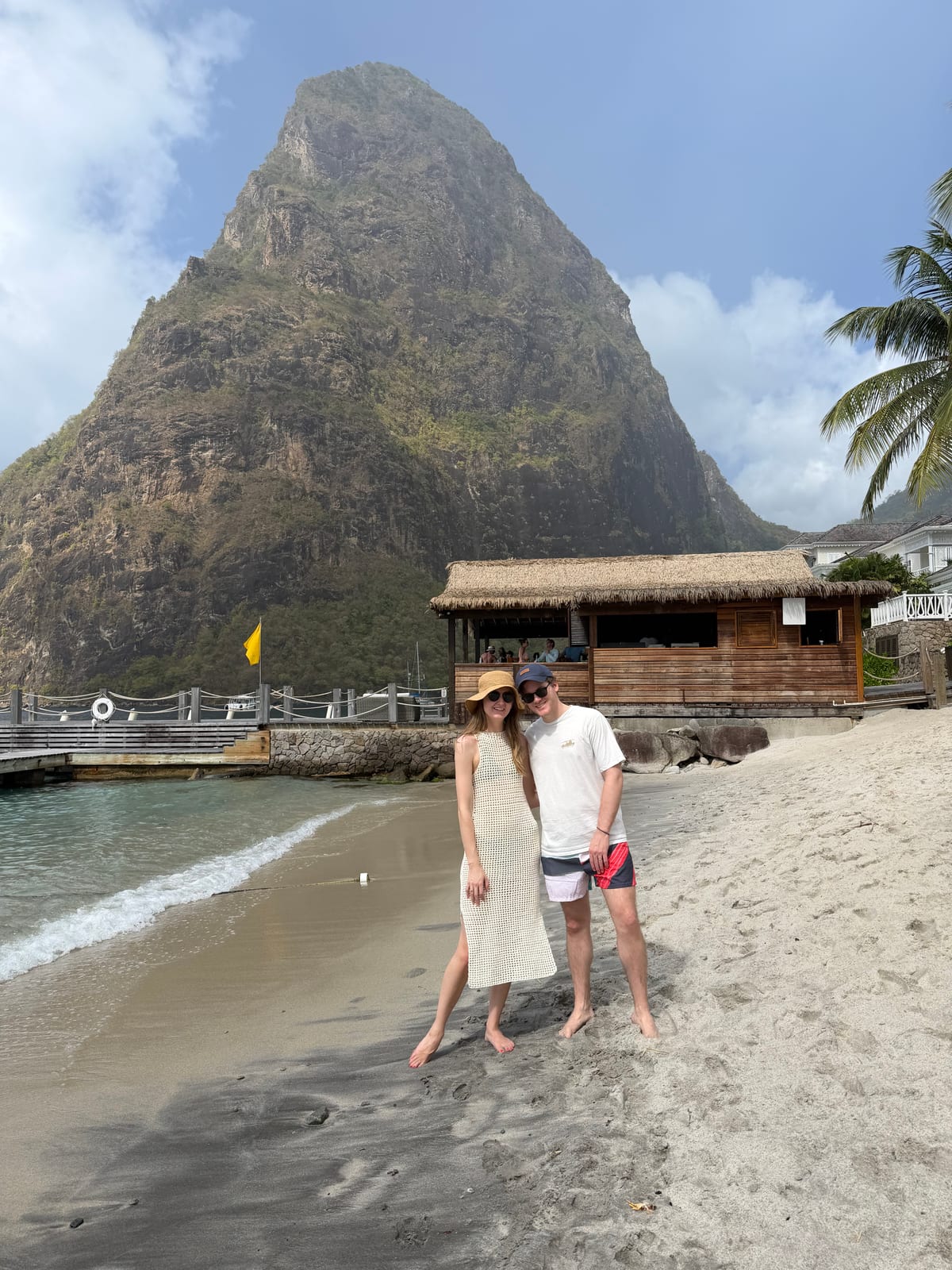 A couple on Sugar Beach below the steep green spire of Petit Piton
